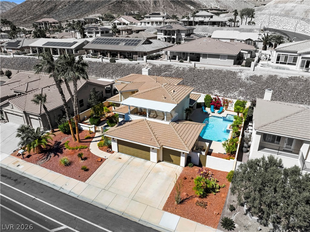 1135 Calico Ridge Drive Henderson, NV 89011 - Photo 60 of 86 An aerial perspective reveals a desert home featuring a refreshing swimming pool, a private patio, and an attached garage.
