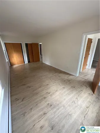 a view of an empty room with wooden floor