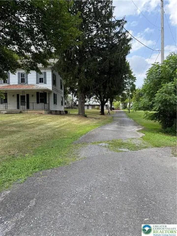a front view of a house with a yard and trees