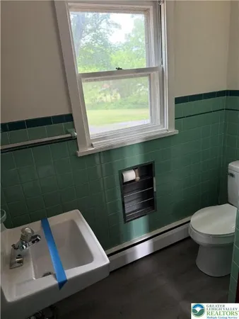 a bathroom with a sink toilet and window