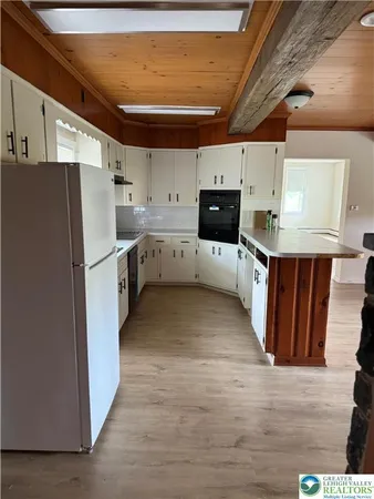 a kitchen with cabinets and wooden floor