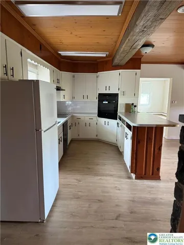 a kitchen with cabinets and wooden floor