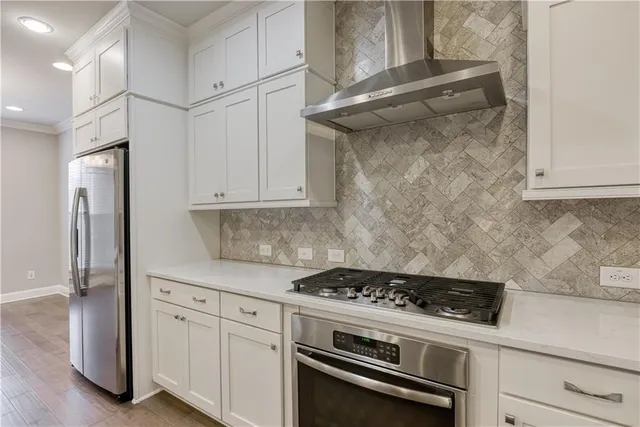 a kitchen with stainless steel appliances white cabinets and a stove