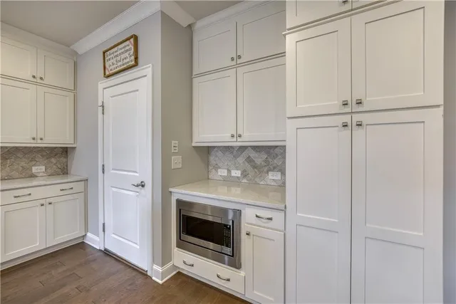 a kitchen with white cabinets and white appliances