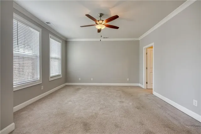 an empty room with window and ceiling fan