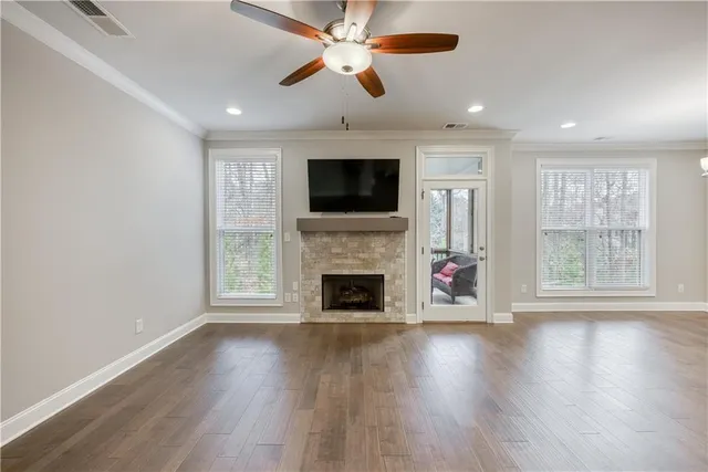 an empty room with fireplace wooden floor and windows