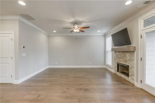 an empty room with fireplace fan and windows