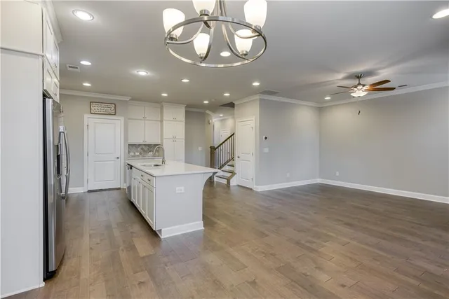 a large white kitchen with a large window appliances and cabinets