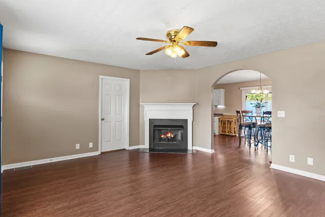a view of a livingroom with wooden floor and a fireplace