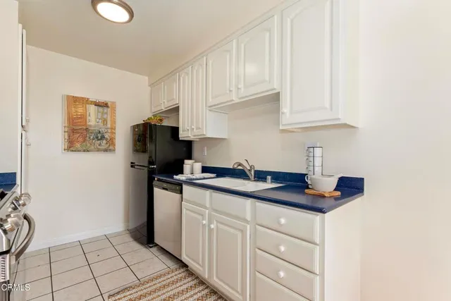 a kitchen with granite countertop white cabinets and stainless steel appliances