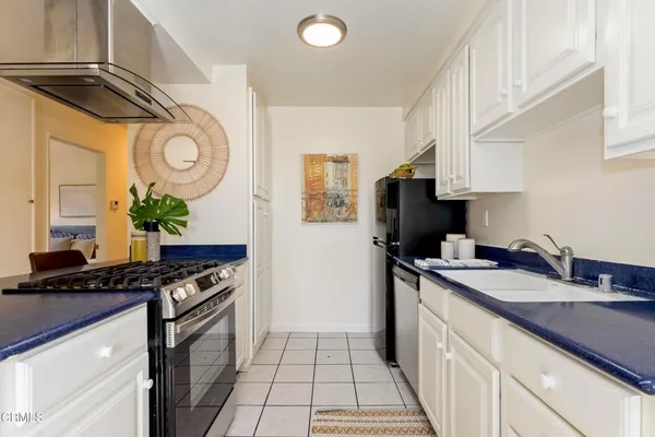 a kitchen with stainless steel appliances granite countertop a sink a stove and a refrigerator