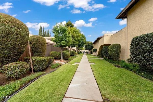 a front view of a house with a yard and trees
