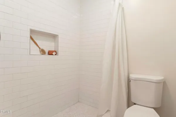 a white toilet sitting next to a shower