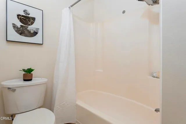 a white toilet sitting next to a bath tub