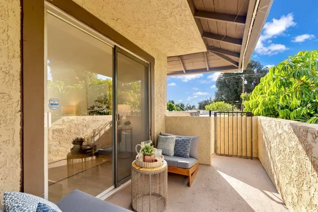 a balcony with furniture and a potted plant