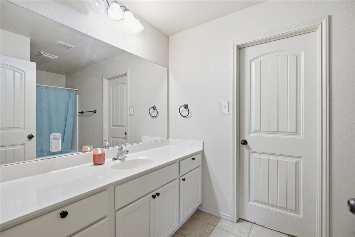 3118 113th Street Lubbock, TX 79423 - Photo 12 of 21 a bathroom with a double vanity sink and mirror