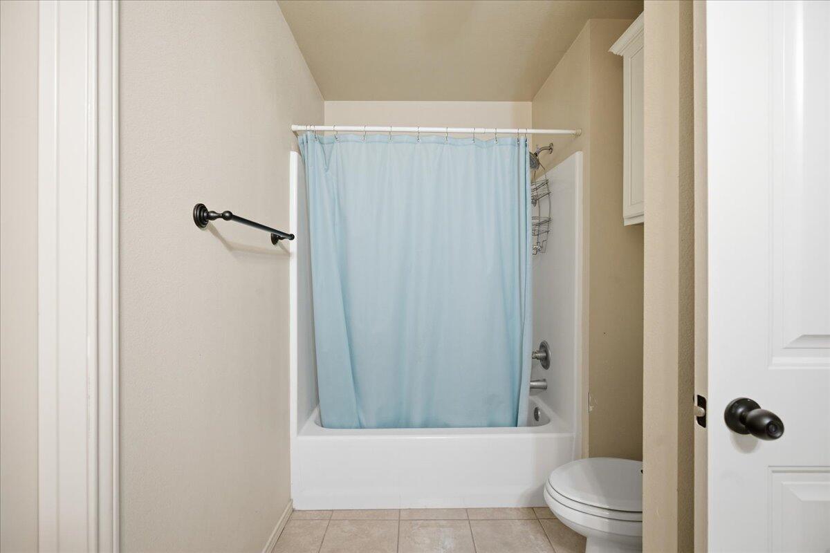 3118 113th Street Lubbock, TX 79423 - Photo 20 of 21 a bathroom with a shower a toilet and a sink