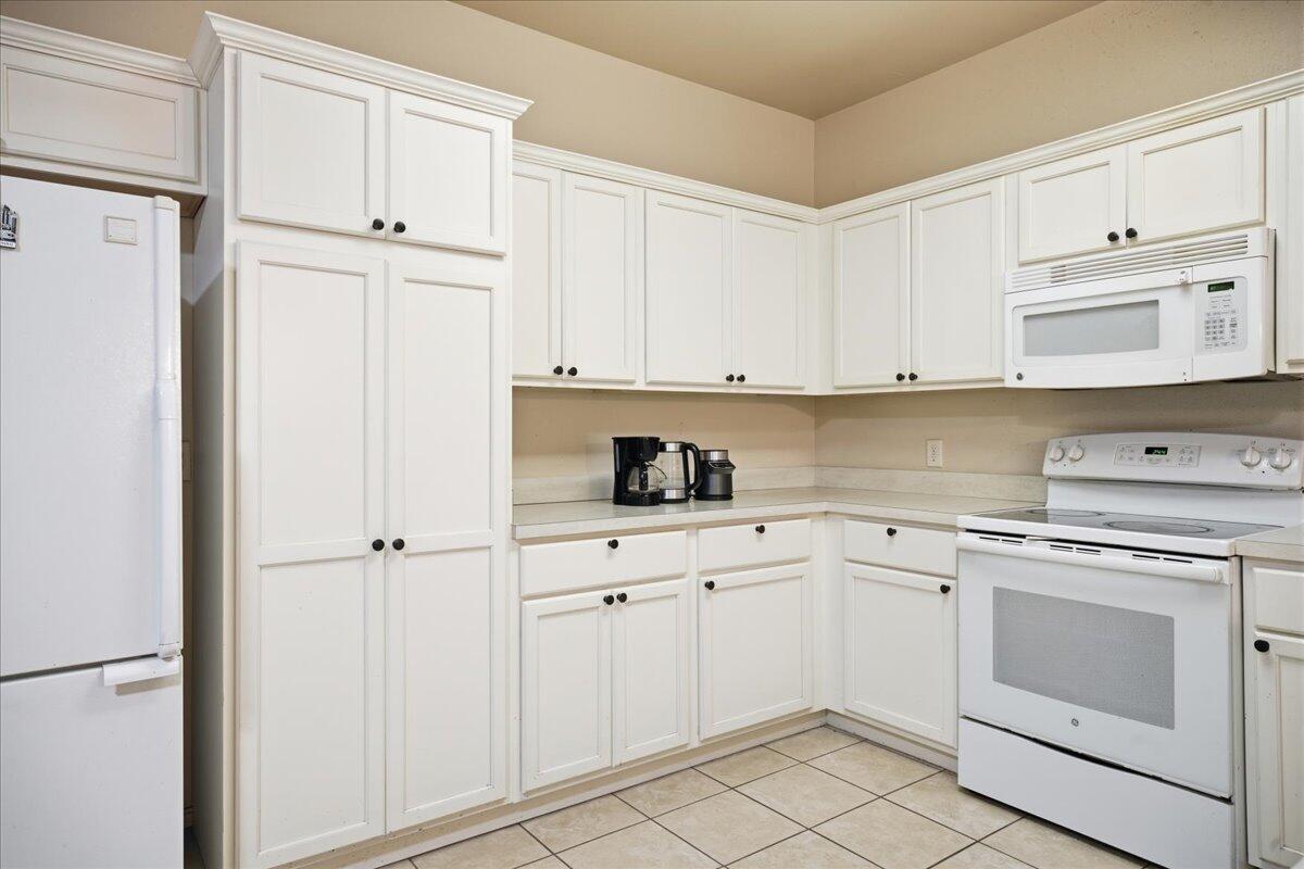 3118 113th Street Lubbock, TX 79423 - Photo 7 of 21 a kitchen with white cabinets and white appliances