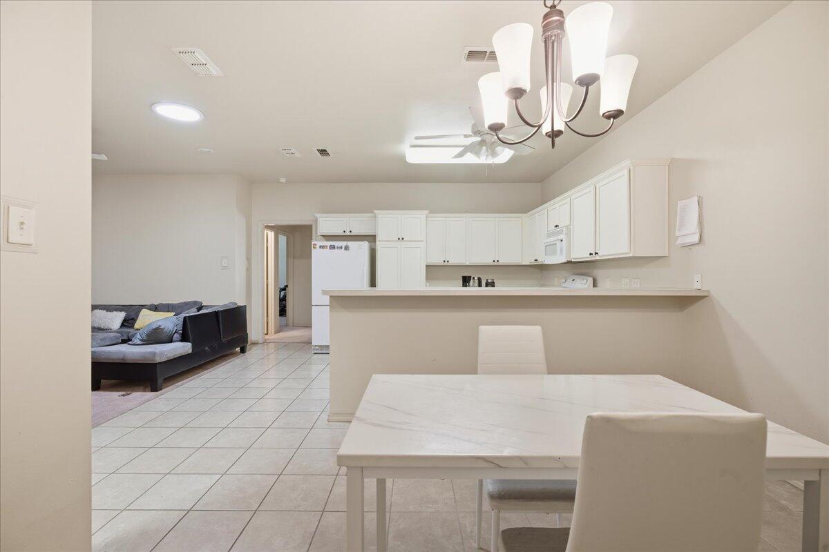 3118 113th Street Lubbock, TX 79423 - Photo 10 of 21 a living room with stainless steel appliances furniture a chandelier and a view of kitchen