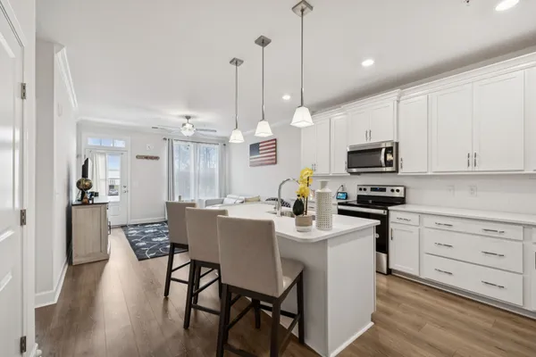 a kitchen with microwave a stove a table and chairs