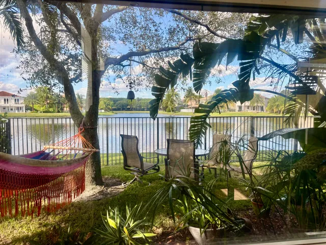 a living room with stainless steel appliances furniture a couch and a kitchen view