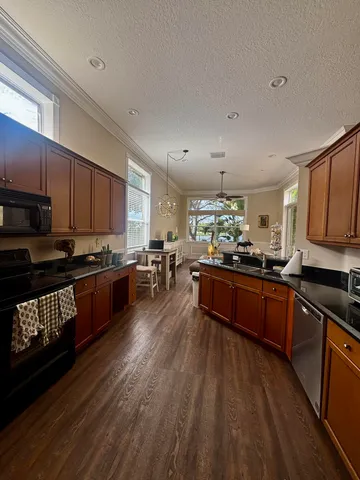 a living room with furniture a flat screen tv and kitchen view