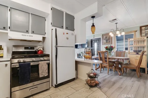 a kitchen with stainless steel appliances kitchen island granite countertop a refrigerator and a stove top oven