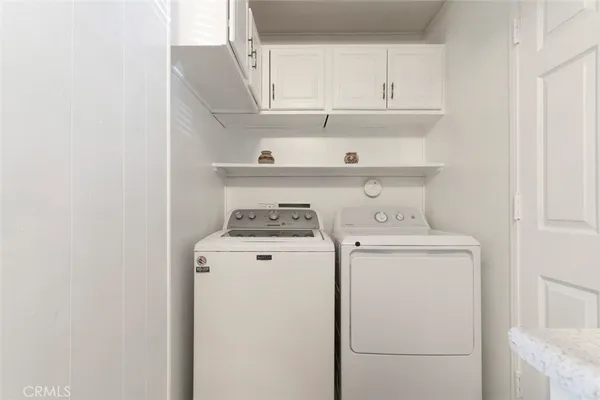 a view of washer and dryer with kitchen in the background