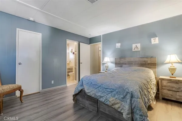 a spacious bedroom with a bed and a lamp