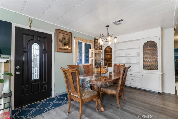 a view of a a dining room with furniture window and wooden floor
