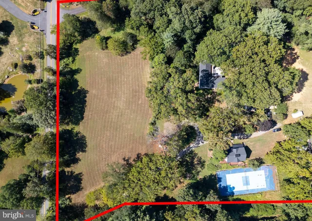 an aerial view of residential house with outdoor space and trees all around