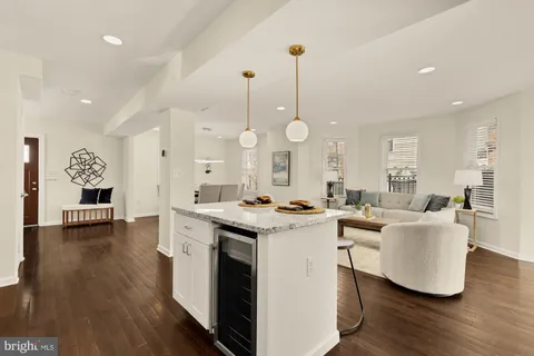 a open kitchen with stainless steel appliances granite countertop a stove a sink dishwasher and a dining table with wooden floor