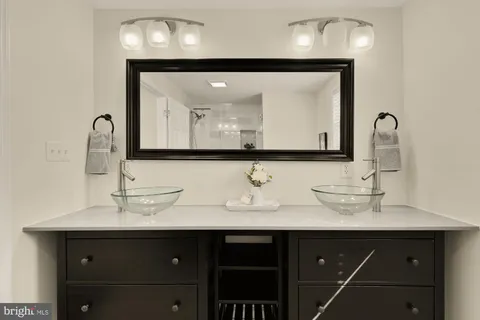 a bathroom with double vanity sink and a mirror