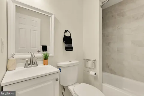 a bathroom with a toilet sink vanity tub and shower