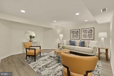 a living room with furniture and a wooden floor