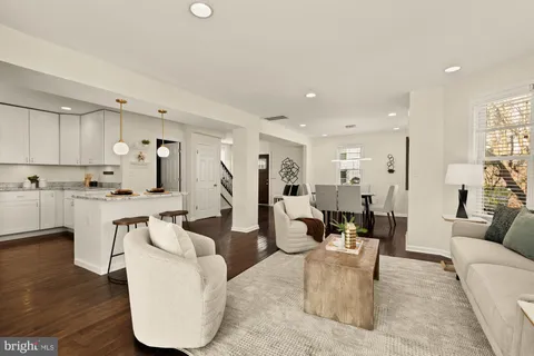 a living room with furniture and a dining table with kitchen view