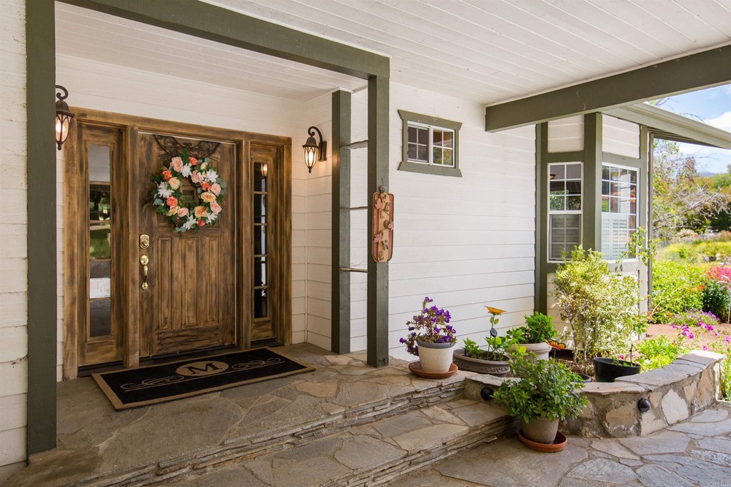 1793 Rocrest Road Alpine, CA 91901 - Photo 20 of 63 a front view of a house with a potted plant and floor to ceiling window