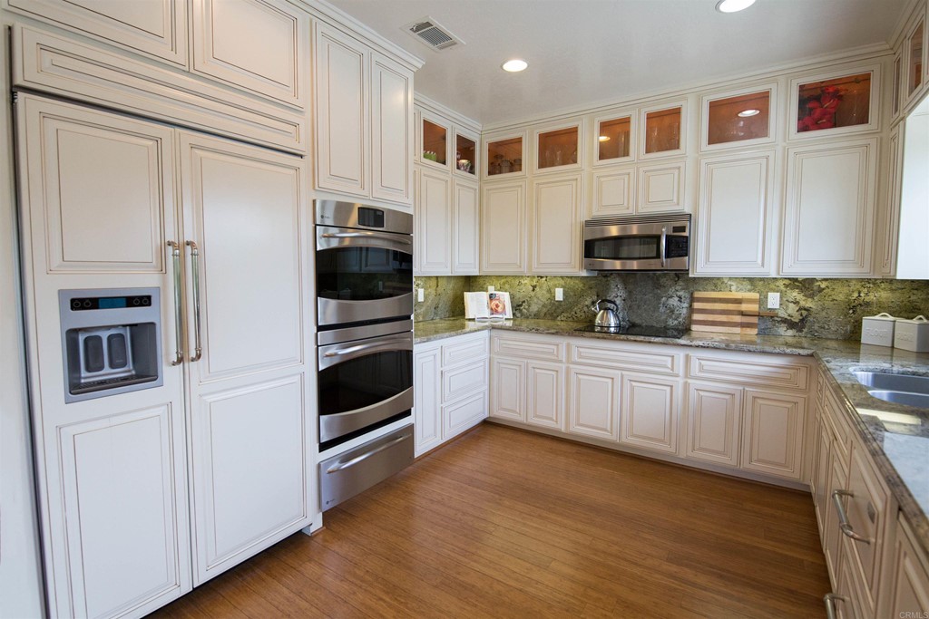 1793 Rocrest Road Alpine, CA 91901 - Photo 26 of 63 a kitchen with stainless steel appliances a stove a refrigerator a sink and white cabinets