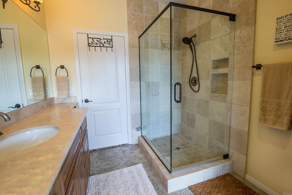 1793 Rocrest Road Alpine, CA 91901 - Photo 53 of 63 a bathroom with a granite countertop sink a mirror a vanity and shower