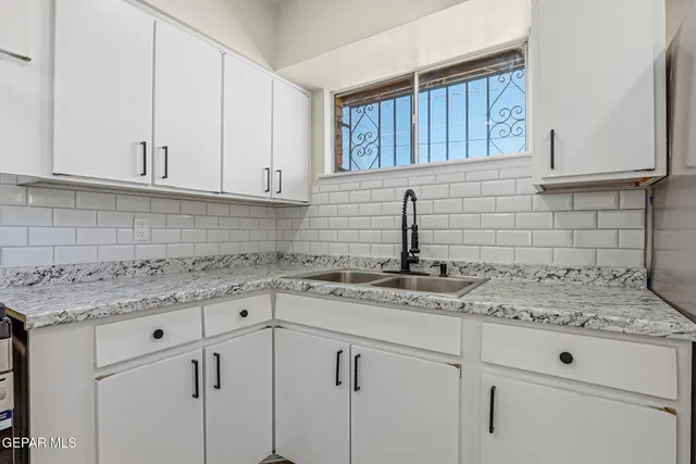 a kitchen with granite countertop white cabinets and white appliances