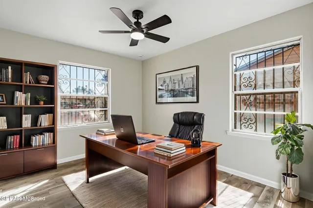 a view of a workspace with furniture and a window