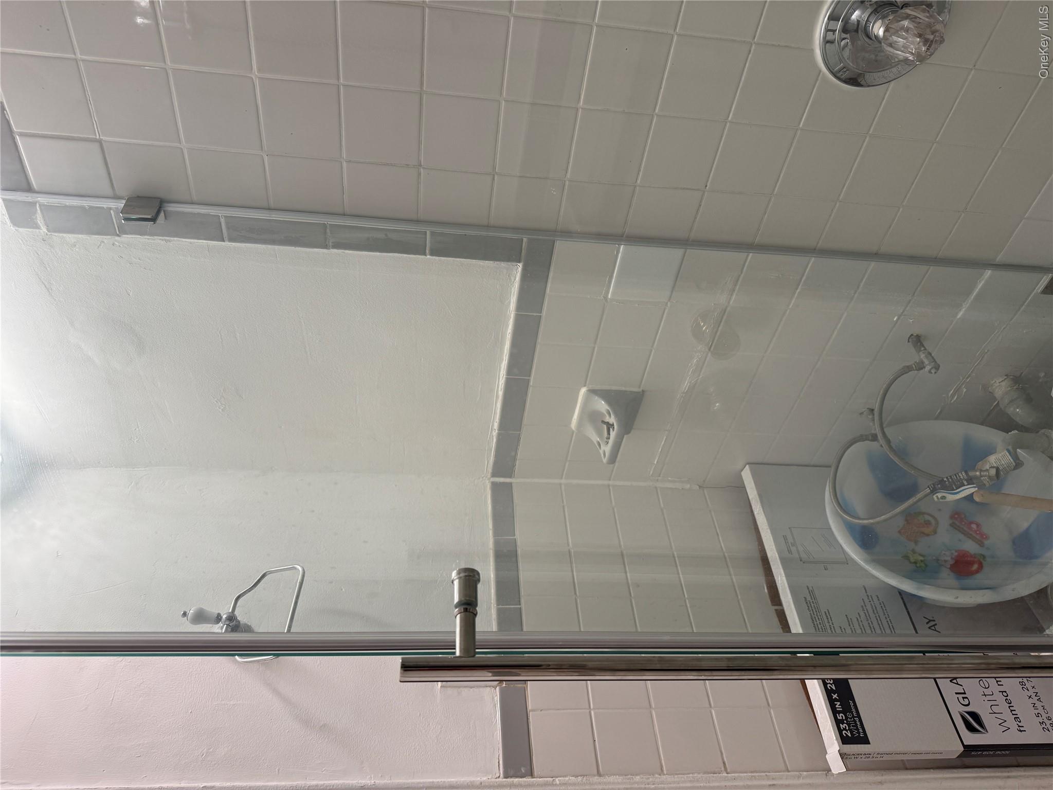 141-17 78th Road, Unit 1O Queens, NY 11367 - Photo 11 of 17 Bathroom with tile walls, washer / clothes dryer, and a tile shower