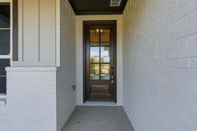 a view of an empty room with a window and kitchen view