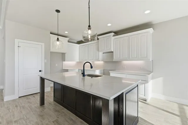 a kitchen with kitchen island a sink appliances and cabinets