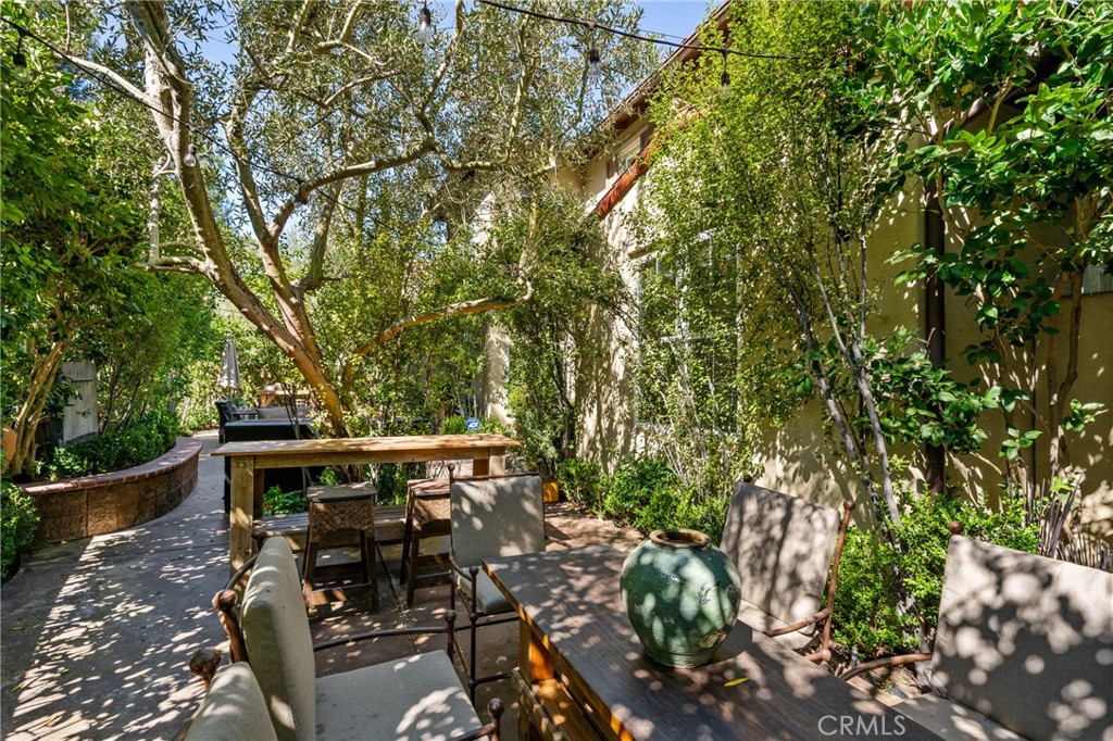 140 White Flower Irvine, CA 92603 - Photo 28 of 44 a view of a patio with table and chairs under an umbrella with large trees