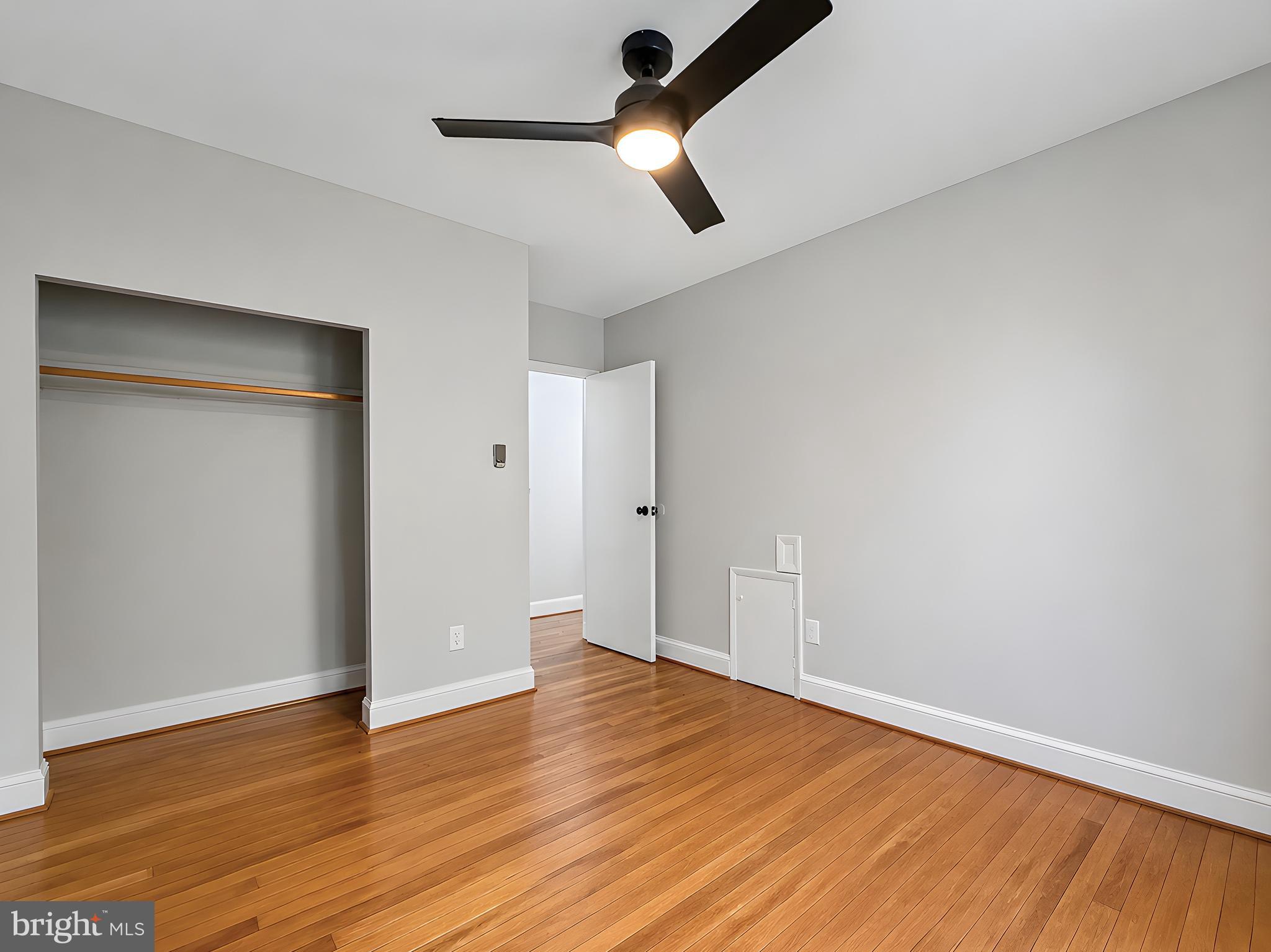 17248 Gum Landing Road St. Inigoes, MD 20684 - Photo 19 of 56 an empty room with wooden floor chandelier fan and windows