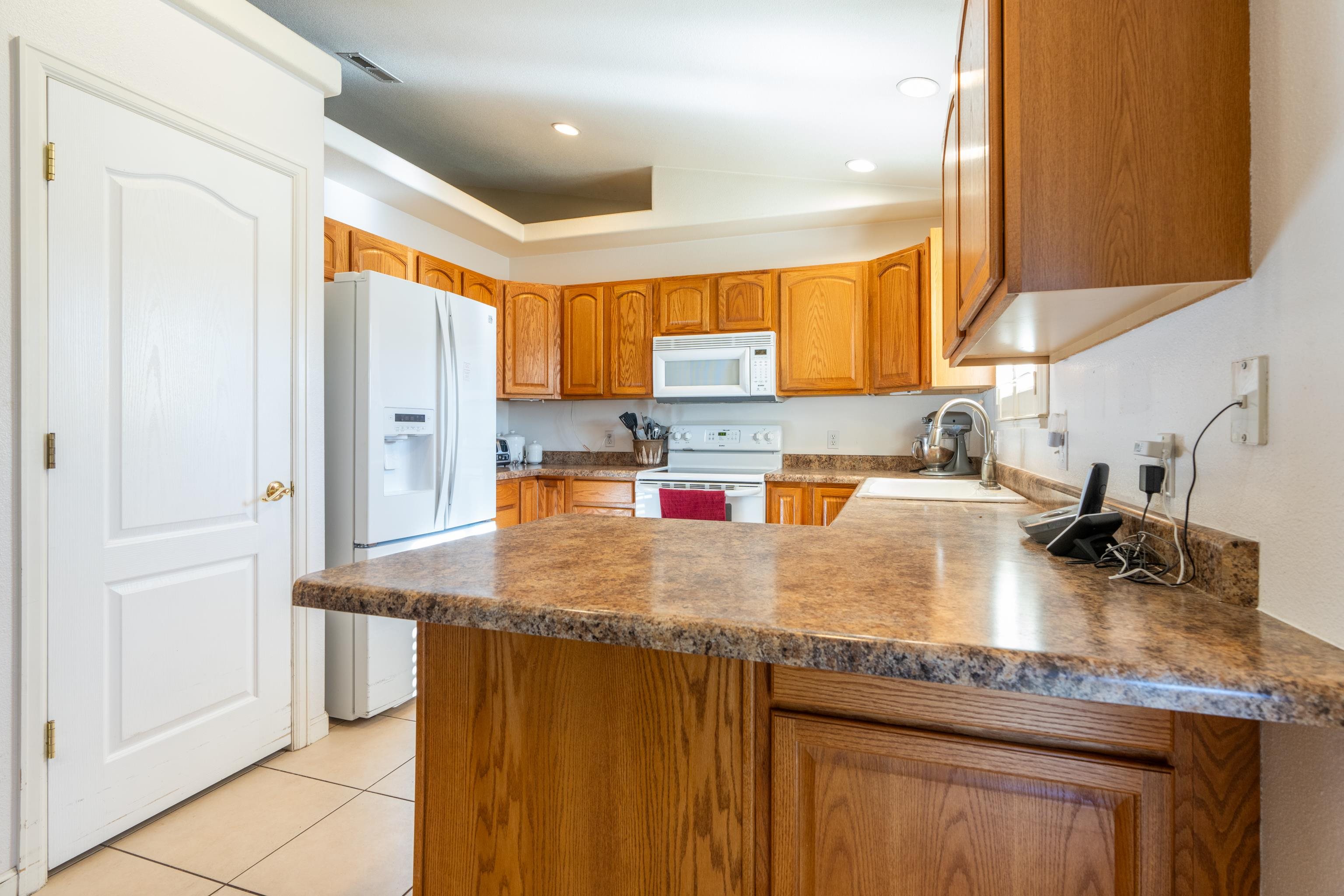 653 Hall Street Fruita, CO 81521 - Photo 9 of 25 a kitchen with kitchen island granite countertop a sink a counter top space and cabinets