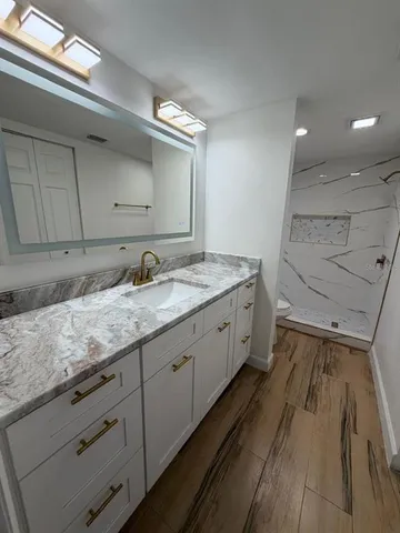 a spacious bathroom with a granite countertop sink and a mirror