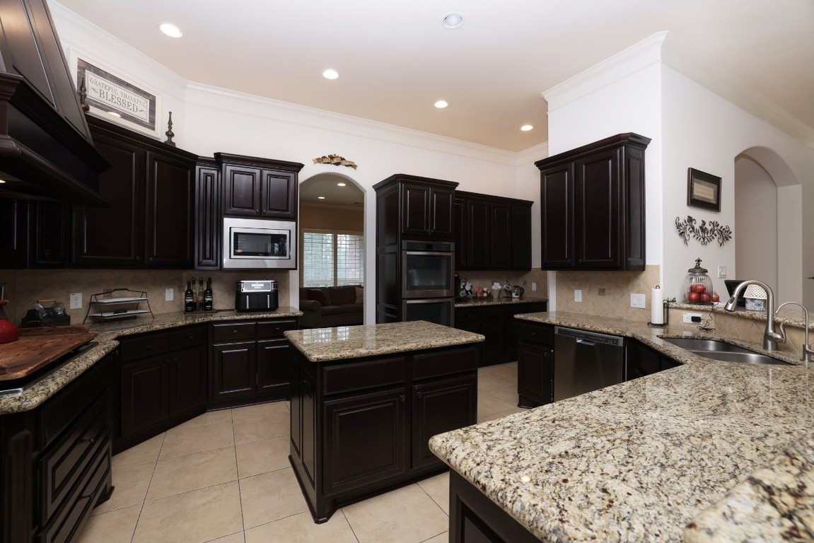 1547 Ruby Drive Willis, TX 77378 - Photo 17 of 45 a kitchen with stainless steel appliances granite countertop a sink wooden cabinets and a granite counter tops