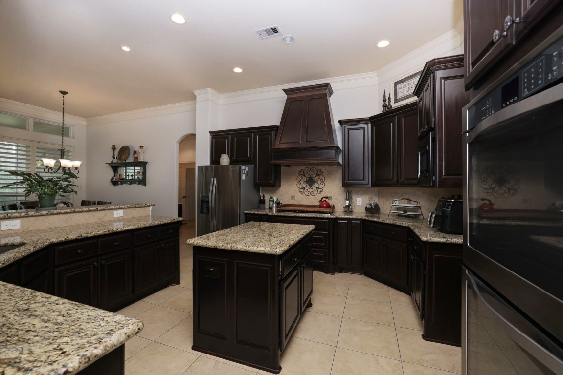 1547 Ruby Drive Willis, TX 77378 - Photo 18 of 45 a kitchen with stainless steel appliances kitchen island granite countertop a sink stove and refrigerator